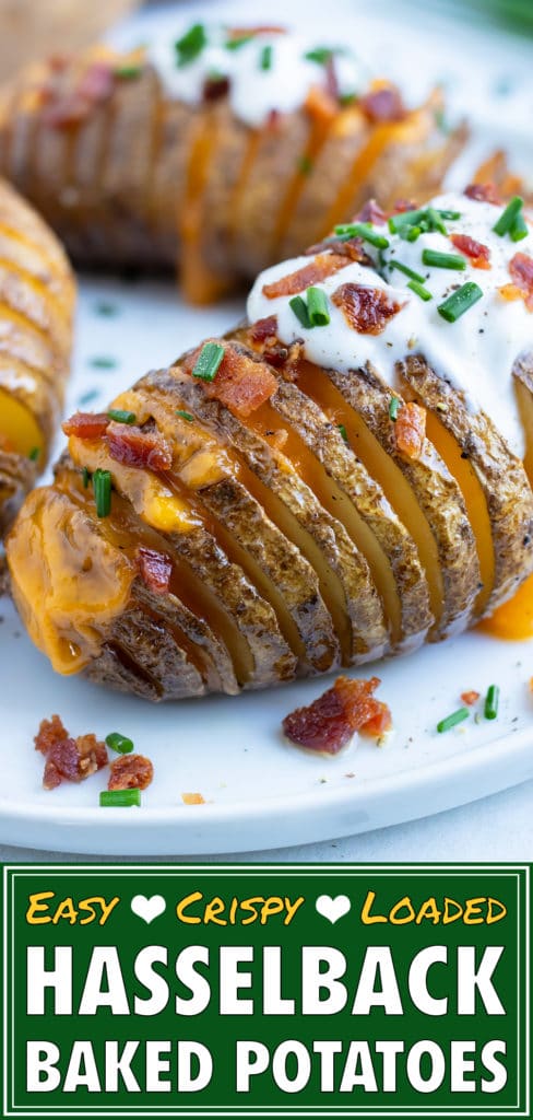 Oven-baked Hasselback Potatoes are served on a white plate with sour cream and bacon.