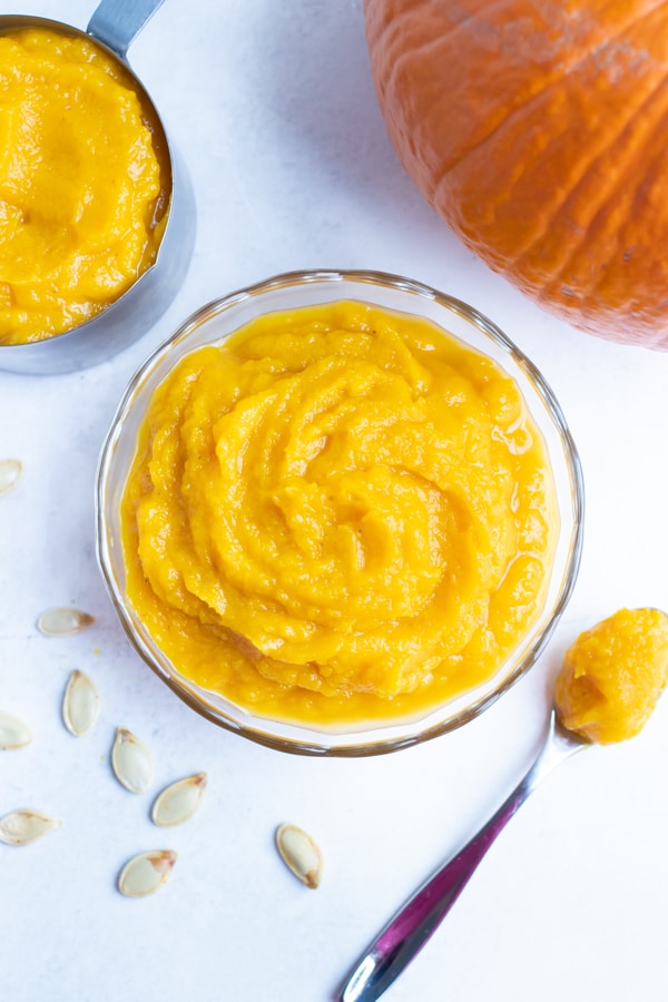 Homemade pumpkin puree is placed in a glass bowl before using in fall recipes.