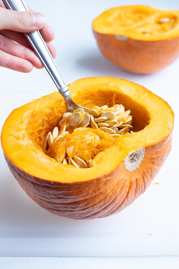 Insides are removed from the pumpkin halves with a spoon.