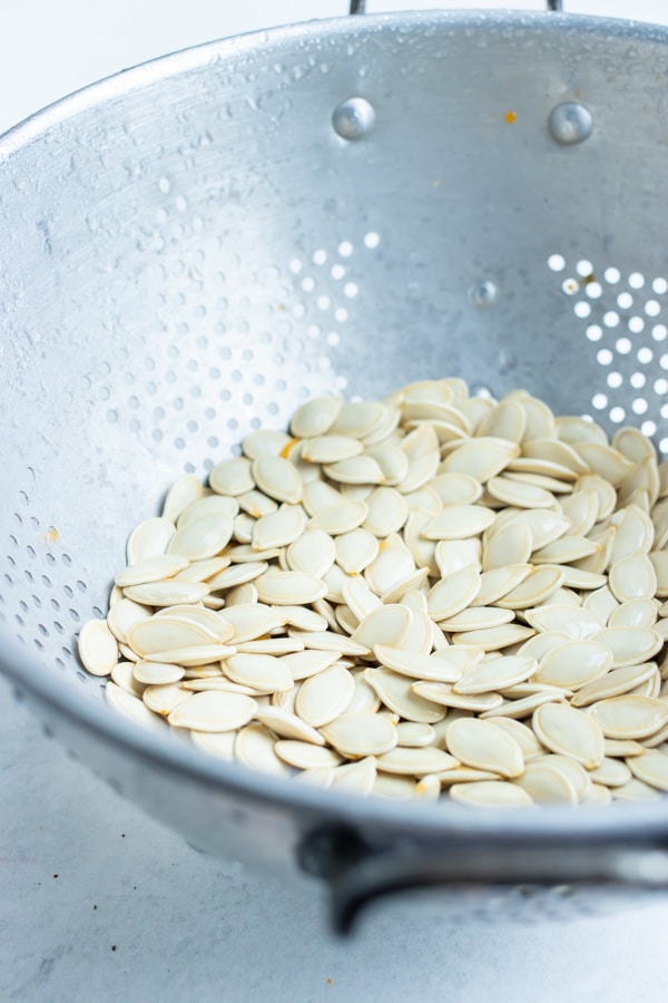 Seeds are placed in a colander to clean before roasting in the oven.