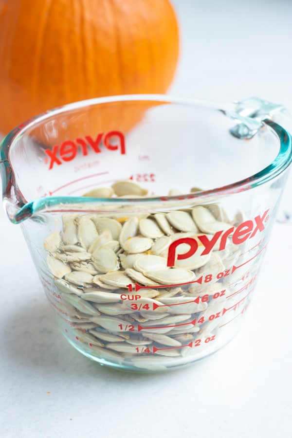 Pumpkin seeds are measured out before coating in oil and seasonings.