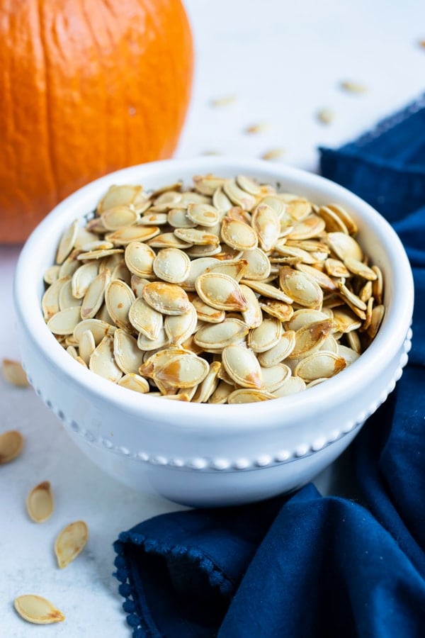Roasted Pumpkin Seeds RECIPE served in a white bowl.