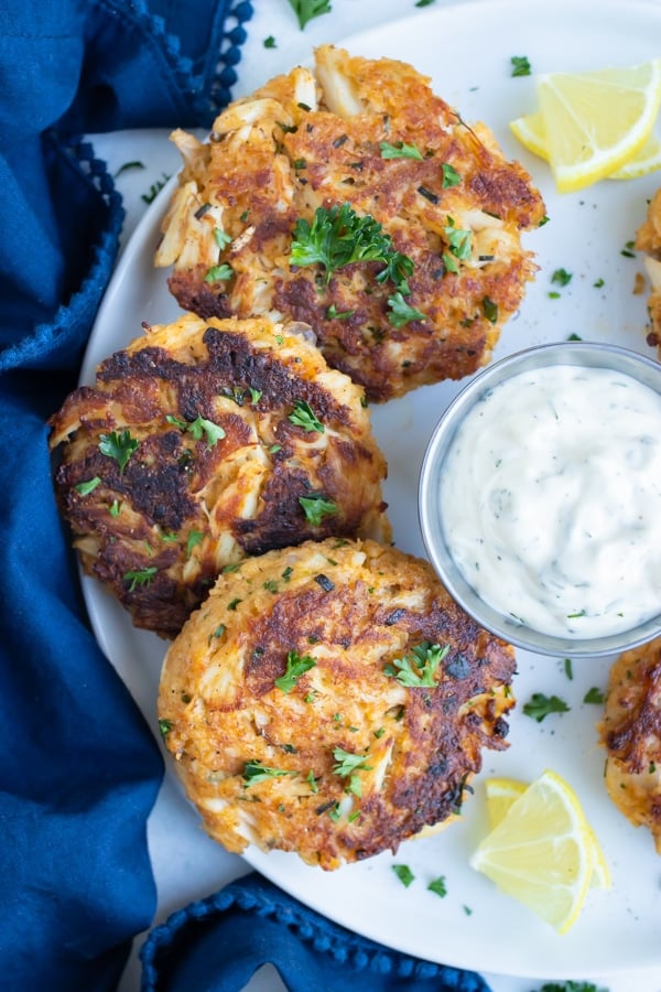 Easy gluten-free crab cakes are served with a tartar sauce.