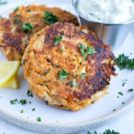 Skillet-seared crab cakes are served with fresh lemon juice, parsley, and tartar sauce.