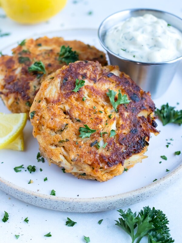 Skillet-seared crab cakes are served with fresh lemon juice, parsley, and tartar sauce.