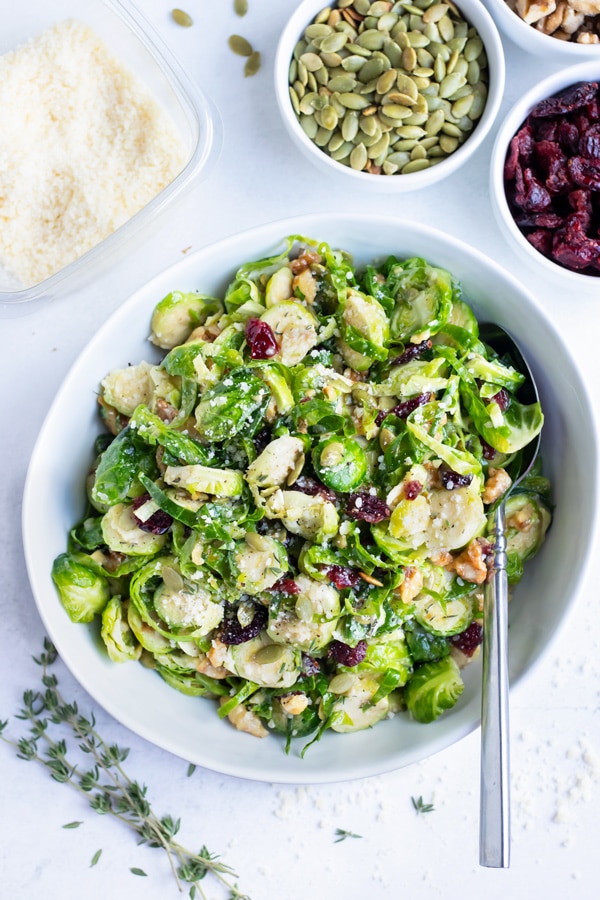 Shaved Brussels sprout salad is served with cranberries and toasted walnuts.