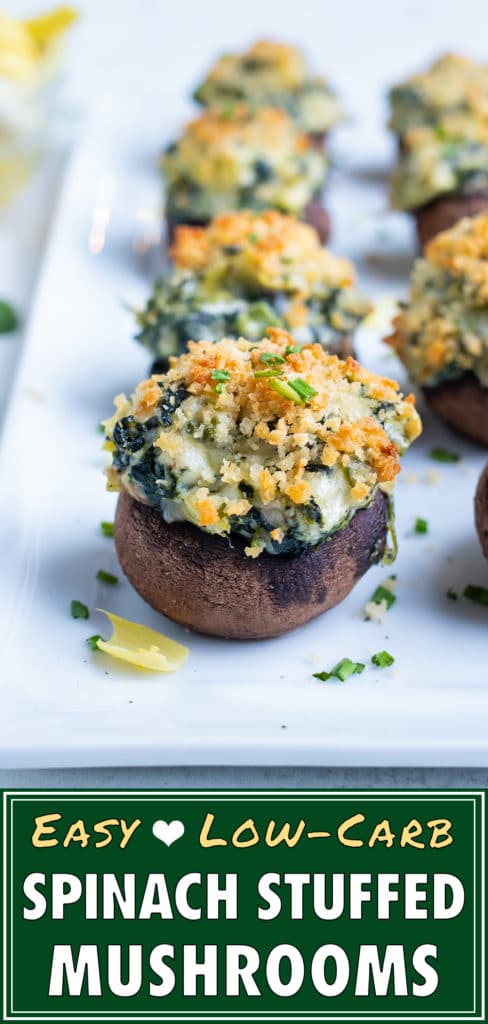 Spinach artichoke stuffed mushrooms are lined up on a tray for serving.