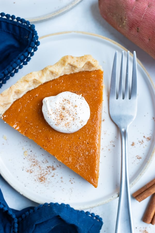 A fork lays beside a slice of sweet potato pie.