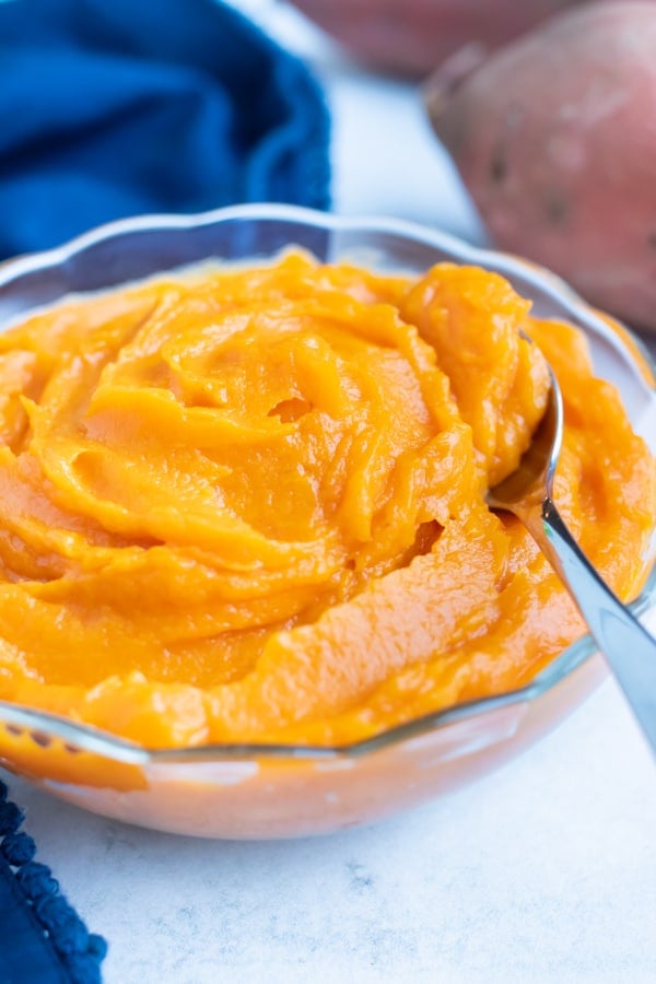 Homemade sweet potato puree in a glass bowl has a smooth and creamy texture.