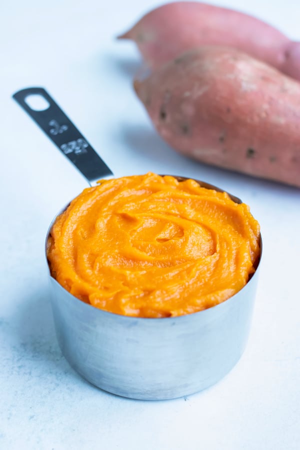 Homemade sweet potato puree is put in a measuring cup for dessert recipe.
