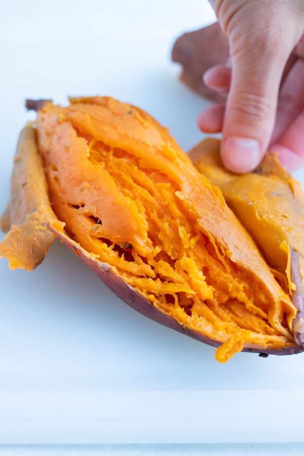 Cooked sweet potatoes are peeled using your hand.