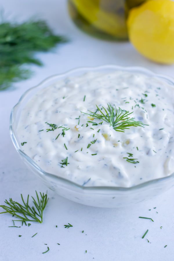 Creamy tartar sauce recipe is served in a bowl with fresh dill.