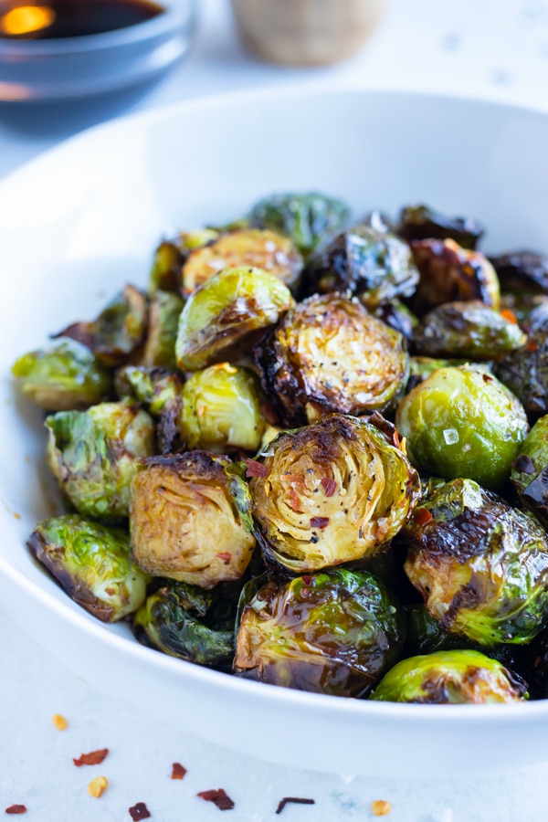 Air fryer roasted brussels sprouts are served in a white bowl.