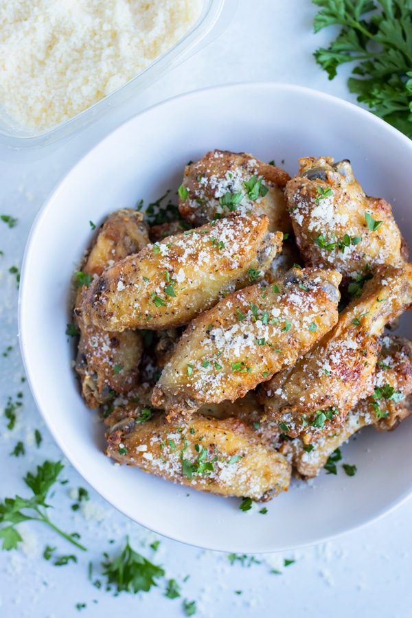 Easy air fryer chicken wings are served in a white bowl for an appetizer.