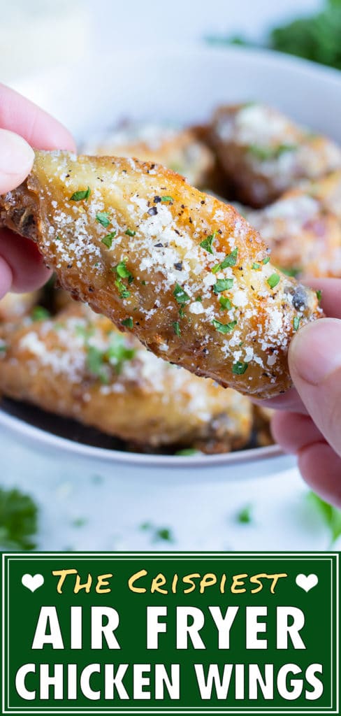 Crispy air fryer chicken wings are picked up for an appetizer.