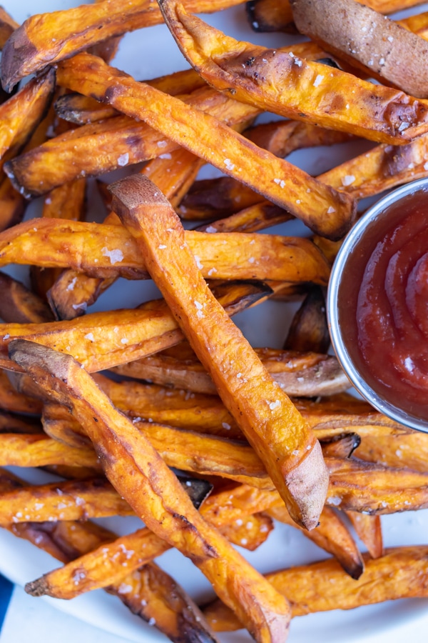 Crispy, healthy air fryer sweet potato fries are served with ketchup.