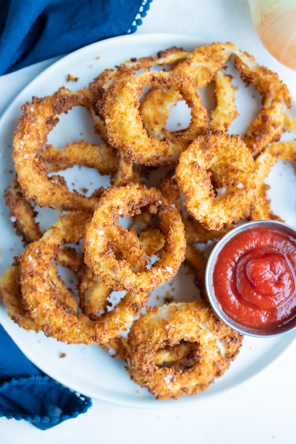 A plate of onion rings is set on the counter for a quick and easy side dish.