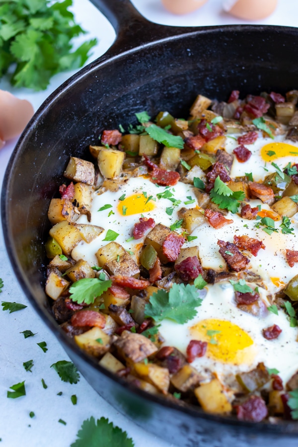 Potato hash and eggs are cooked in one pot for an easy recipe.