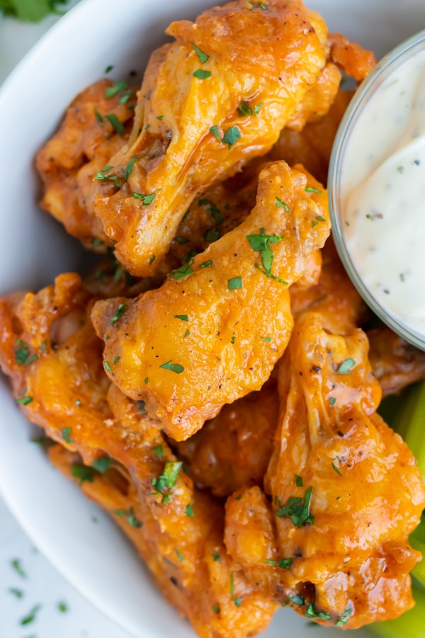 Buffalo chicken wings are served for a low-carb, healthy main dish on a plate.