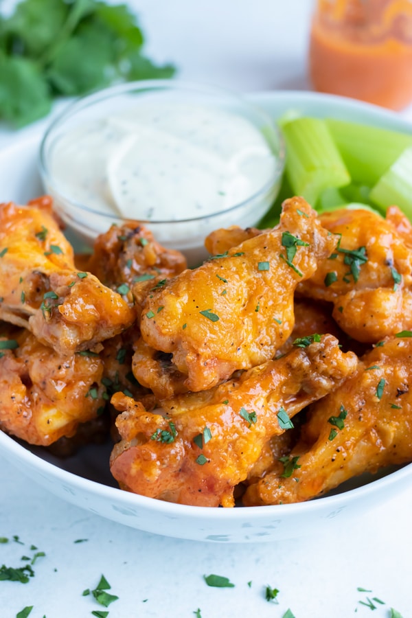 Ultra crispy buffalo wings are served on a plate as party food.