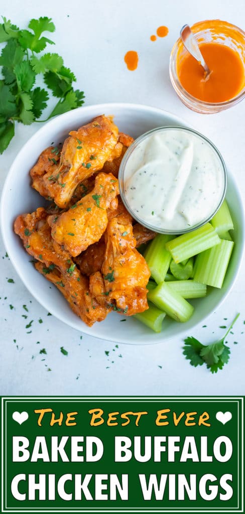 Baked buffalo chicken wings are served with blue cheese dressing and celery.