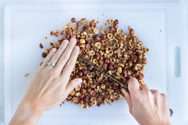 The roasted hazelnuts are chopped finely before blending.