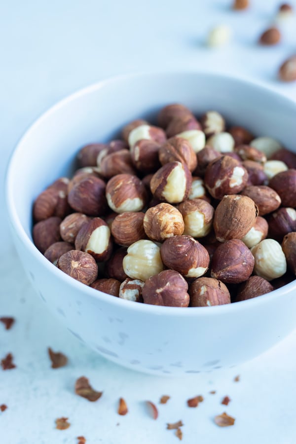 A bowl of toasted hazelnuts is set on the counter for snacking.