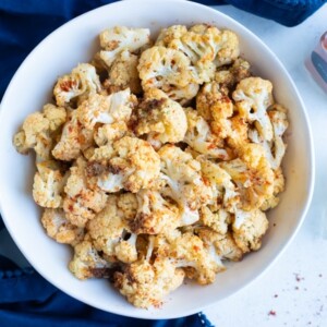 Easy air fryer cauliflower is placed in a white bowl.