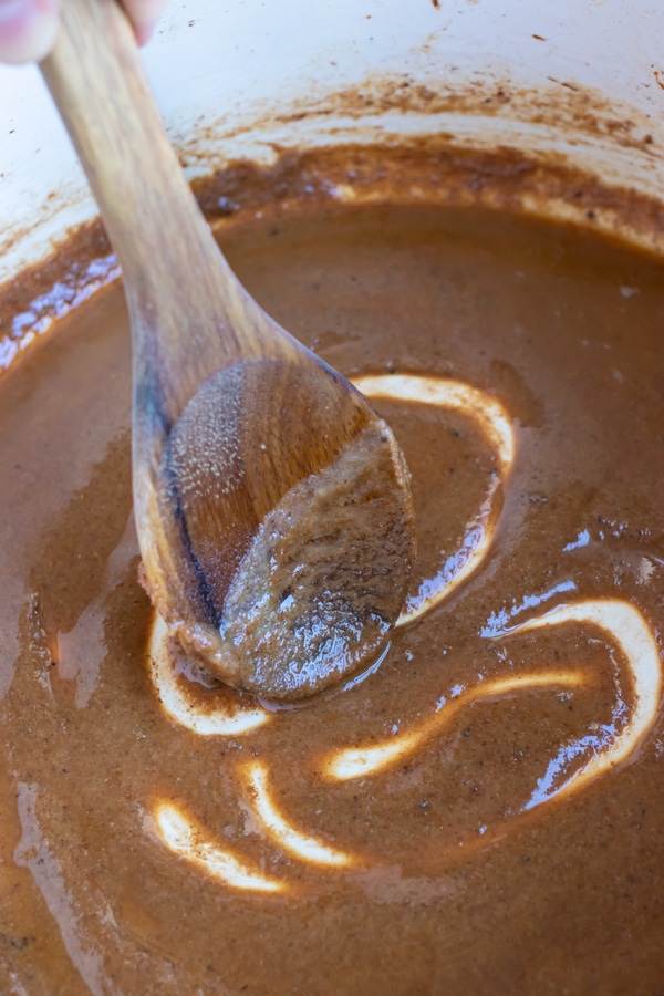 A wooden spoon is used to mix the roux.
