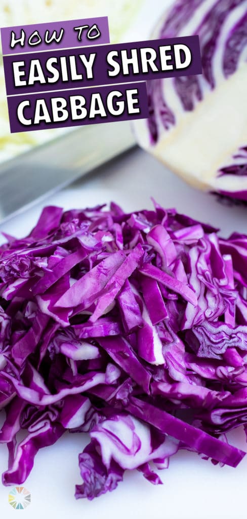 Thinly sliced red cabbage on a white cutting board with a wedge and a knife in the background.