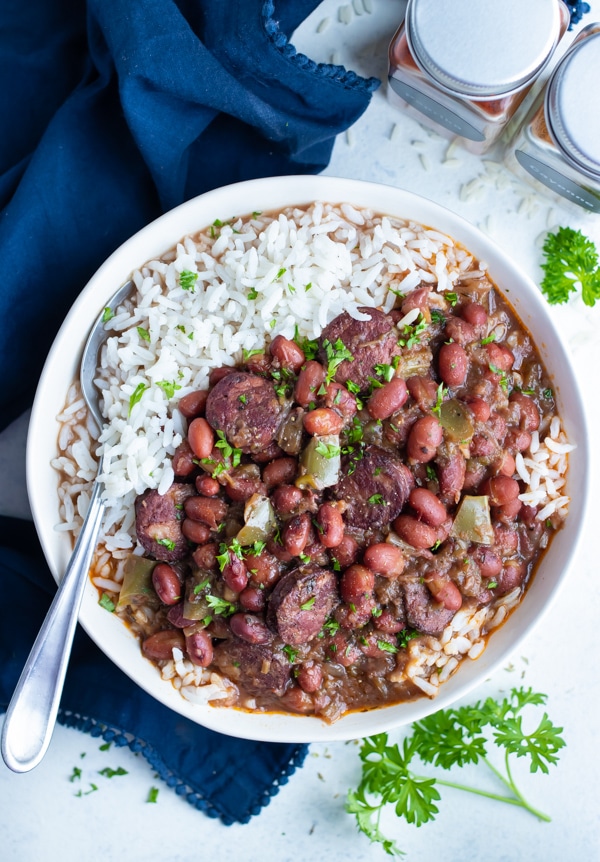 Instant Pot Red Beans and Rice are served in a white bowl with a spoon.
