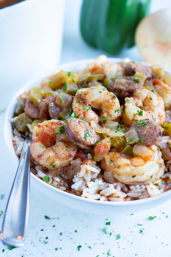 Cajun gumbo is served in a white bowl with rice.