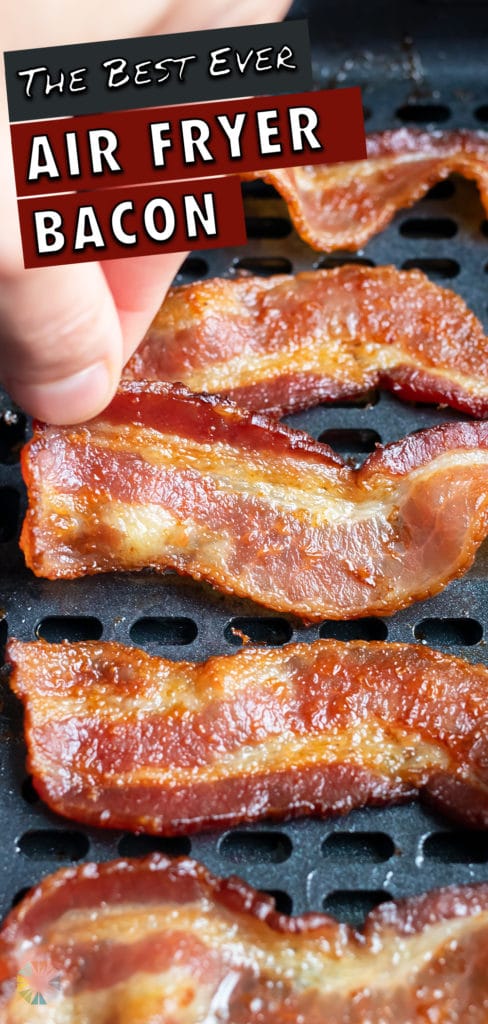 A slice of bacon is taken out of the air fryer after cooking.