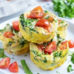 A pile of four egg muffins are served on a white plate.