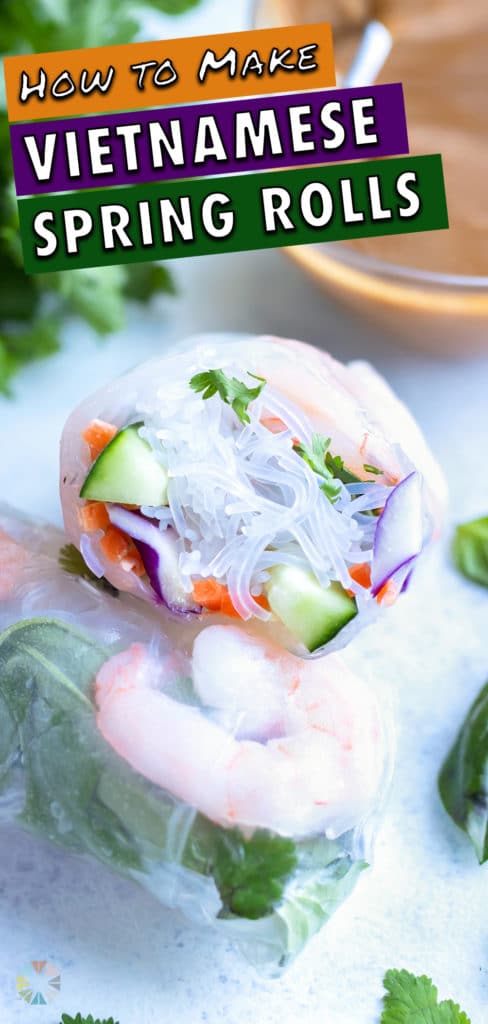 Fresh spring rolls are shown on the counter with herbs and a peanut sauce behind them.