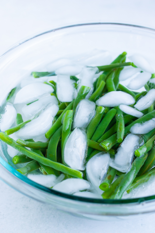 Blanching boiled green beans in an ice water bath.