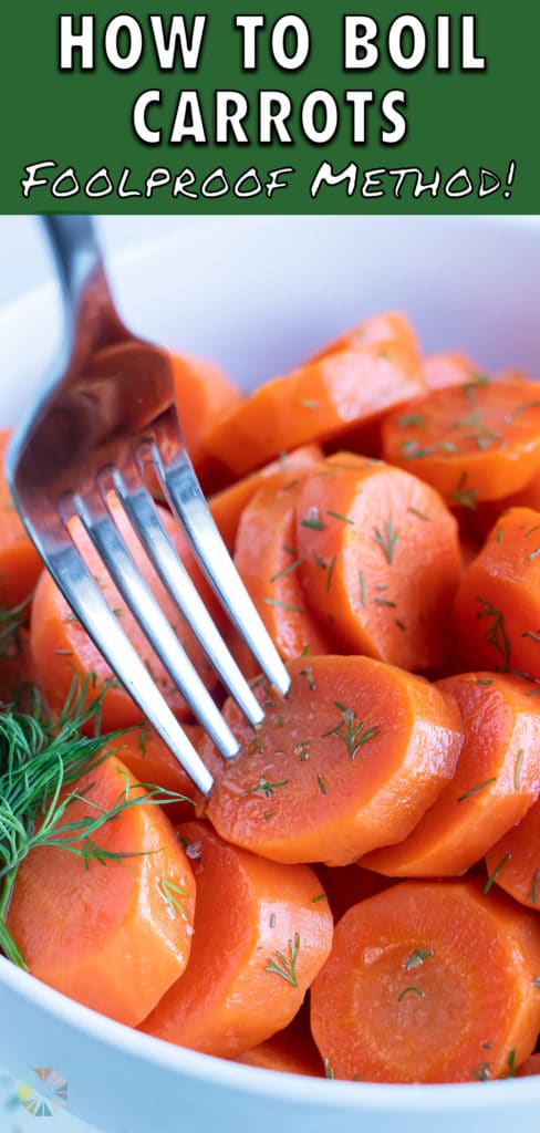 A sliced boil carrot is served with a fork.