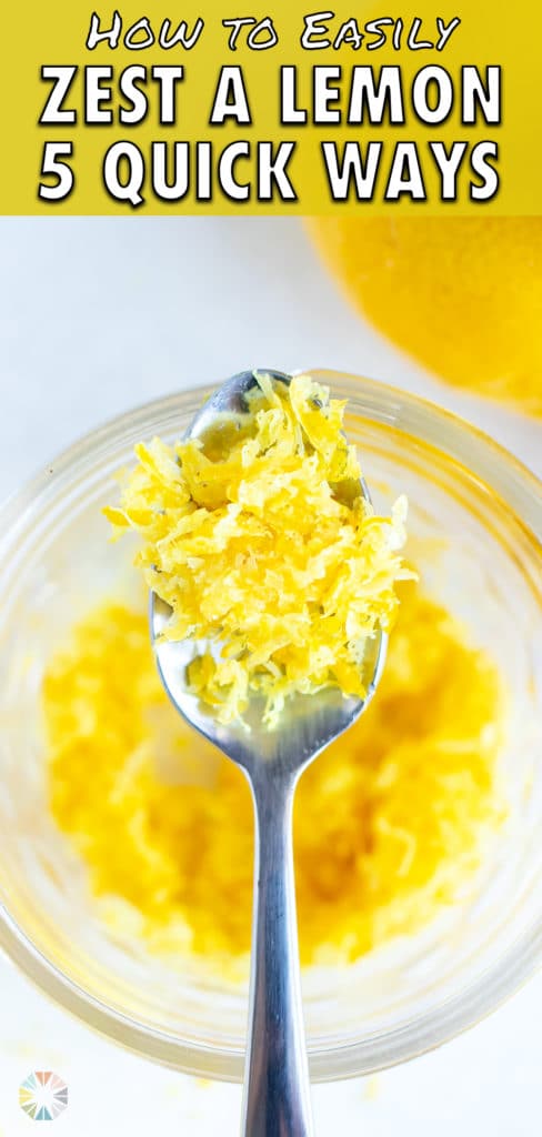 Yellow citrus zest on a spoon over a jar full of it.