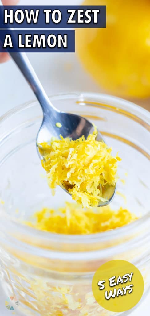A glass jar full of lemon zest and a silver spoon scooping some out.