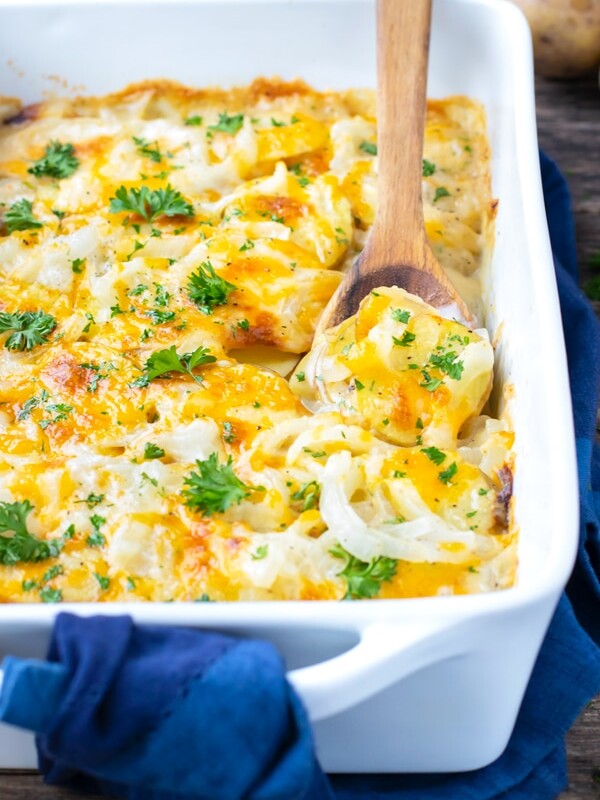 Homemade scalloped potatoes recipe with cheddar cheese and parsley sprinkled on top.