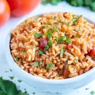 Pressure cooker Mexican rice is topped with fresh cilantro and served from a bowl.