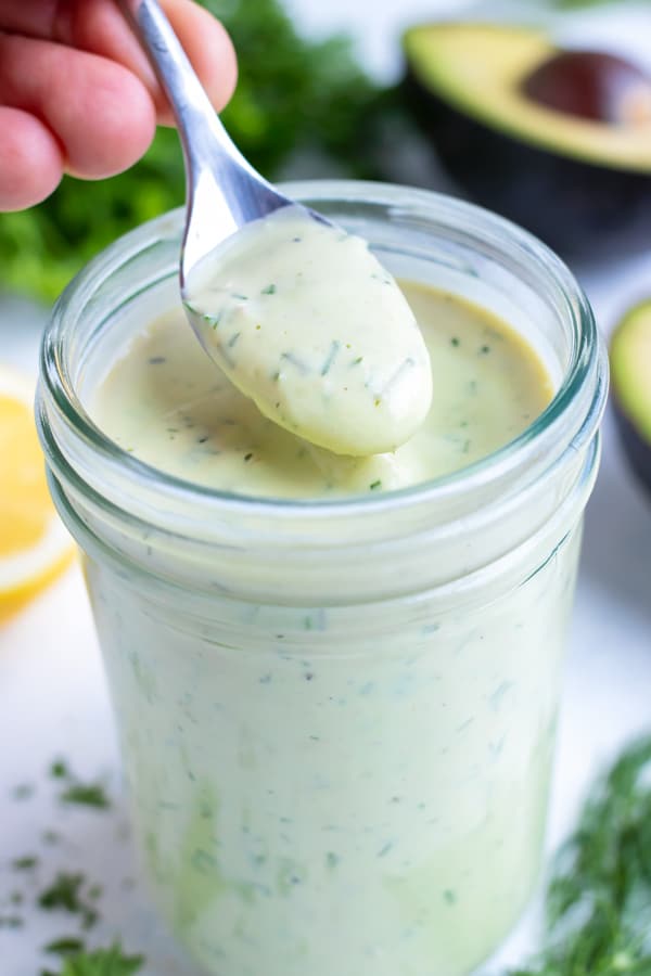 Creamy avocado dressing is served with a spoon .