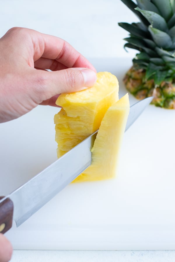 The core is removed from the pineapple with a knife.