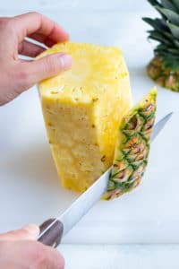 The whole pineapple skin is removed with a knife.I
