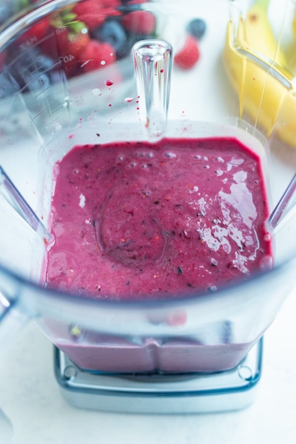 Thick and creamy smoothie is made in a blender.