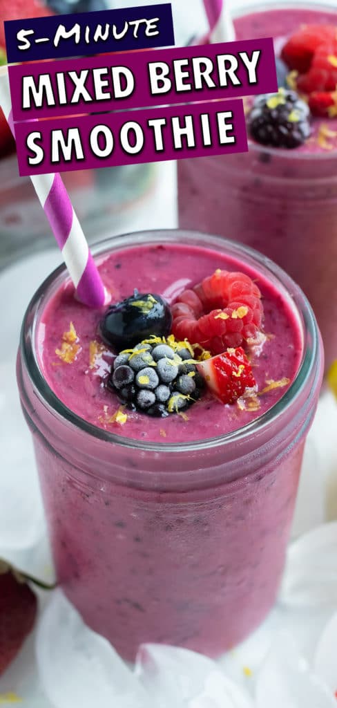 Two mixed berry smoothies are set on the counter in glasses with straws.