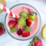 Creamy, fruit smoothie is topped with fresh strawberries and kiwis.