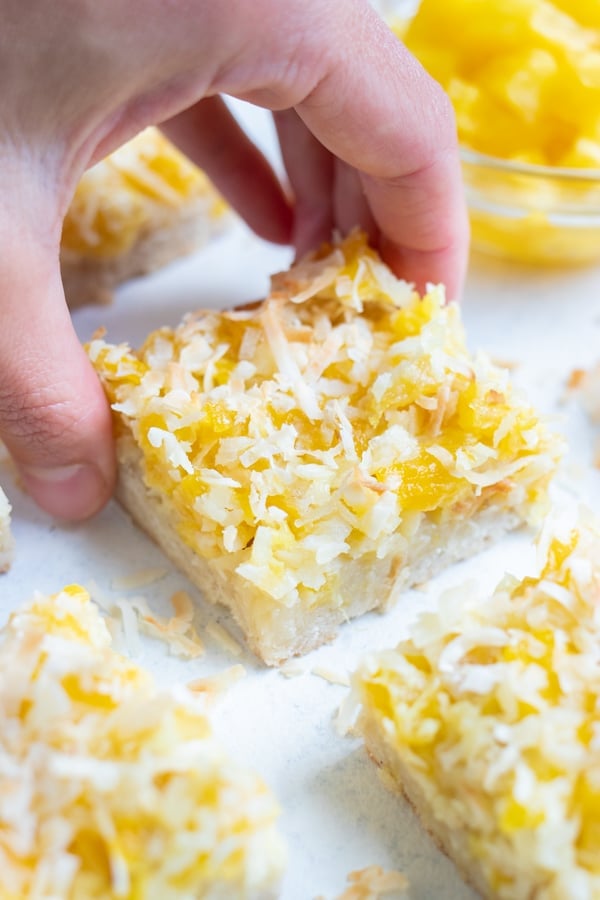 A hand is used to pick up a piña colada bar.