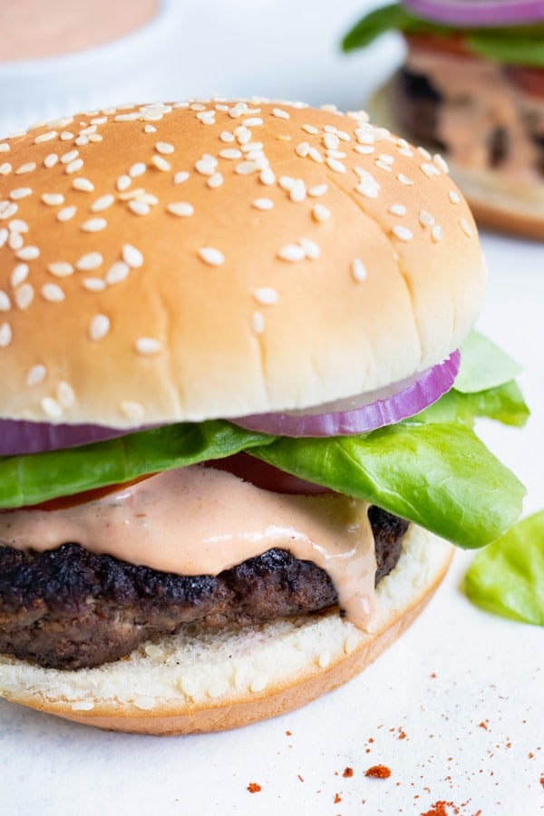 The hamburger is spread with the homemade secret sauce.