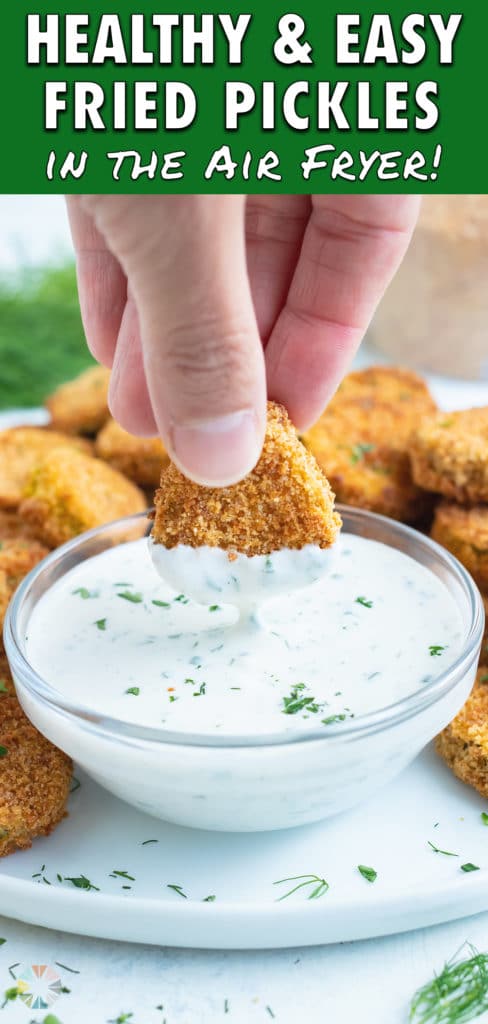 A pickle is dipped into homemade ranch dressing.